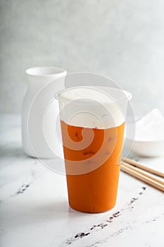 Iced orange mango tea with cold foam in tall glass