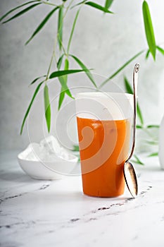 Iced orange mango tea with cold foam in tall glass