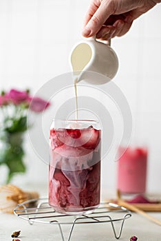 iced pink matcha with milk in tall glass