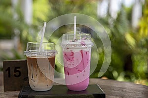 Iced Pink milk, Thai style iced sweet milk with cider syrup and iced  latte coffee  on the wooden table