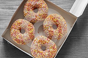 Iced ring doughnuts sprinkled with hundreds and thousands in a card box. Recycling eco friendly packaging photo