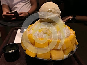 Iced sweetened condensed milk Korean bingsu with sliced mangoes and vanilla ice cream