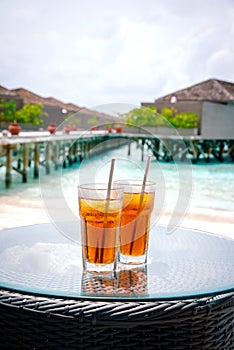 Iced tea against tropical Overwater Bungalow Resort, Maldives.