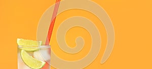 Iced tea with ice and lime on an orange background. Summer cocktail