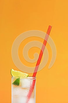 Iced tea with ice and lime on an orange background. Summer cocktail