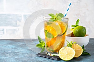 Iced tea with lemon, lime, mint and ice.
