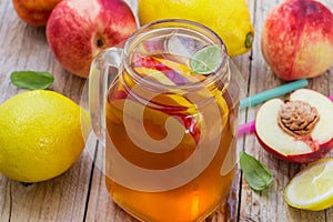 Iced tea with lemon and peach in a Mason jar. Summer soft drink