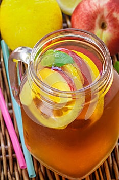 Iced tea with lemon and peach in a Mason jar. Summer soft drink