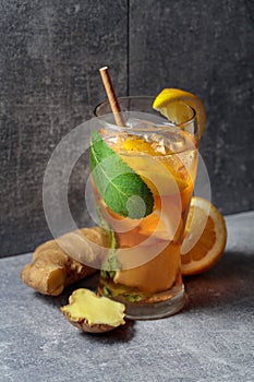 Iced tea with mint, ginger, and lemon on a grey background