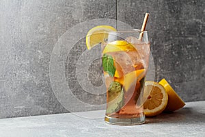 Iced tea with mint and lemon on a grey background