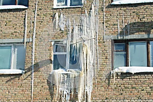 Iced wall of a brick house, emergency situation.