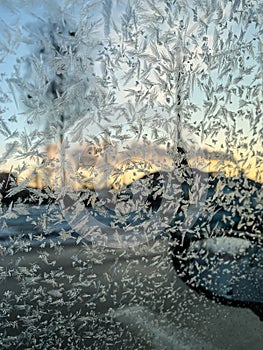 Iceflowers, frozen.The ice-cold frost forms ice crystals in beautiful unique patterns on the window, Hood and wiper on the Car