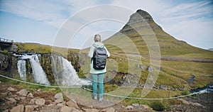 Iceland Female traveler lookint to Green mountain peak and Kirkjufell at morning Summertime adventure trip