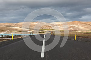 Iceland road with brown mountains on the horizon.