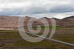 Iceland road with brown mountains on the horizon.