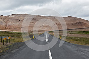 Iceland road with brown mountains on the horizon.