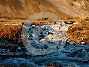 Iceland`s breathtaking mountain landscape in winter, a river with a waterfall. Nature paints