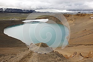 Iceland. Stora-Viti crater with water. Slope with snow.