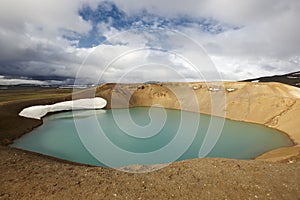 Iceland. Stora-Viti crater with water. Slope with snow.