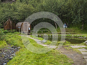 ICELAND, THORSMORK, August 3, 2019: Geothermal hot pool with sauna at the Husadalur Camp in the birch forest in