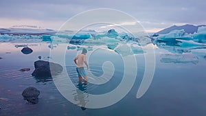 Iceland - Young man getting into the water of Glacier lagoon