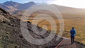 Iceland - Young man walking down the volcano photo