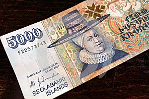 Icelandic cash. Money of Iceland. 5000 Icelandic krona bill on wooden table. Icelandic krona is the national currency of Iceland
