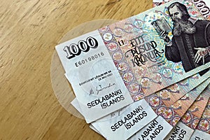 Icelandic cash. Money of Iceland. Several 1000 Icelandic krona bills on wooden table. Icelandic krona is the national currency of