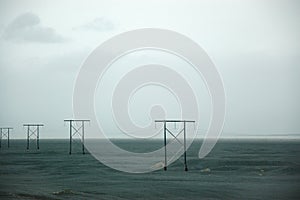 Icelandic electric poles, vast field, rain cloud