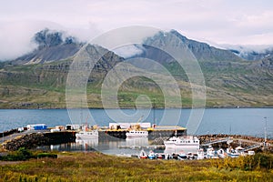 Icelandic fishing boats in the morning at the dock in the fjord in calm weather in summer