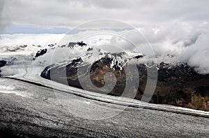 Icelandic glacier and mountains partly hidden in clouds