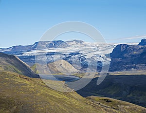 Icelandic landscape with eyjafjallajokull glacier tongue, Markarfljot river and green hills. Fjallabak Nature Reserve, Iceland.