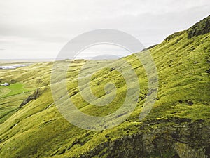 Icelandic landscape with vibrant green hills, drone aerial shot