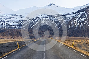 Icelandic road with volcanic snow covered mountains in wintertime, Iceland