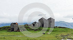 Icelandic sheep grazing infront of abandoned and wrecked farm