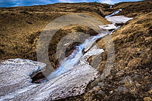 Icelandic wilderness - May 08, 2018: Small waterfall in the icy wilderness of Iceland