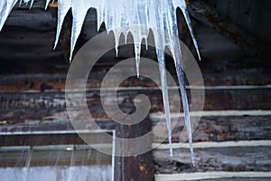 Icicle hanging from roof of rustic cabin