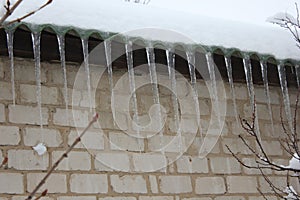 Icicles on the edge of roof of private house