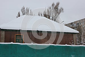 Icicles on the edge of the roof of private house