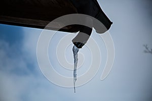 Icicles at gutter, blue sky