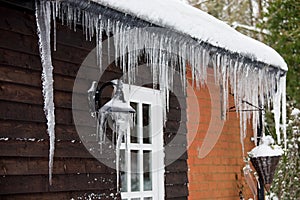 Icicles hanging from a drainpipe ouside a house