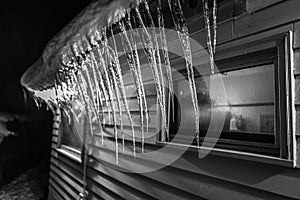 Icicles hanging from an eave at night