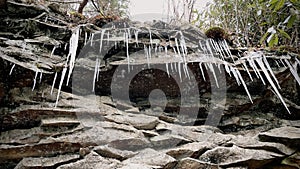 Icicles hanging from rocky cliff