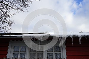 Icicles hanging from the roof of a country house in winter. Biesdorf, Berlin, Germany