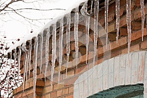 Icicles hanging from the roof. Winter danger