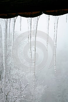 Icicles hanging on the roof. Winter nature abstract art.