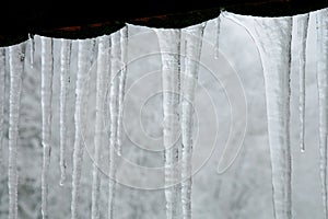 Icicles hanging on the roof. Winter nature abstract art.