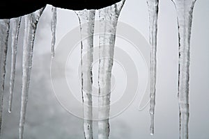 Icicles hanging on the roof. Winter nature abstract art.