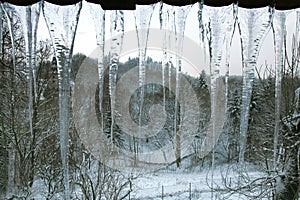 Icicles hanging on the roof. Winter nature abstract art.