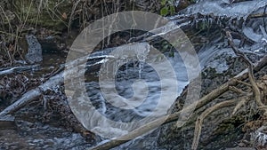 Icicles over the frozen stream in a forest
